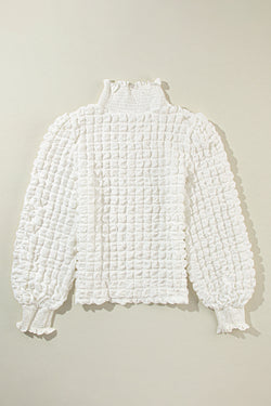 White textured top with puff sleeves and smocked mock neck