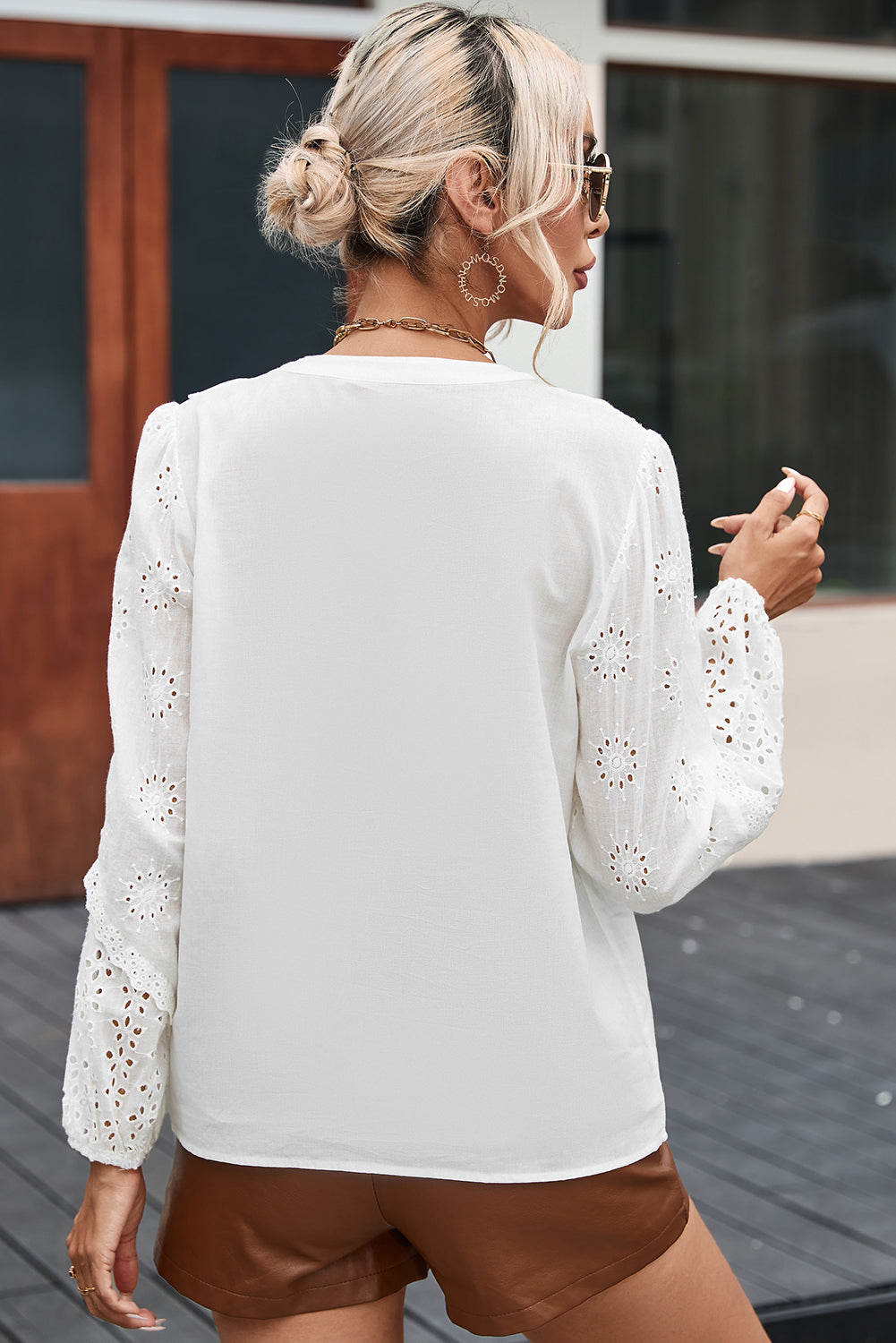 Blouse blanche à col fendu et manches bouffantes en dentelle à œillets