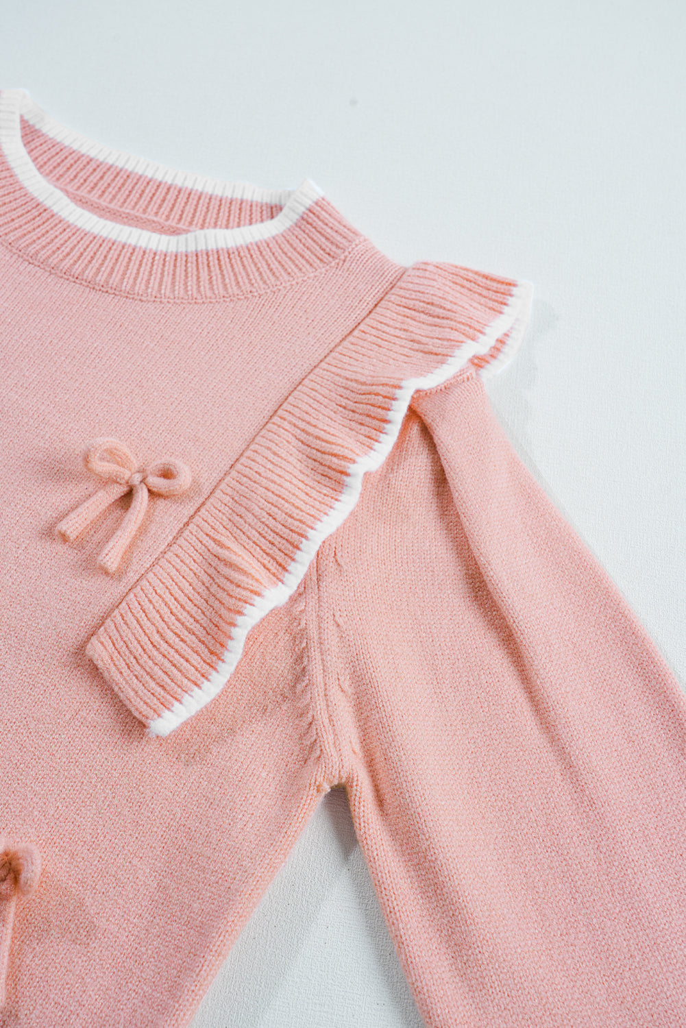 Pull à manches longues et bordure côtelée avec nœud papillon et volants rose clair