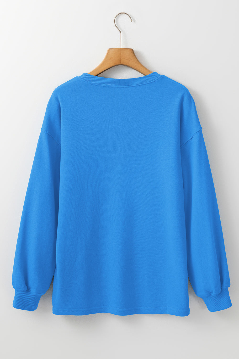Sudadera básica con manga larga y hombros que caen en un cielo azul liso