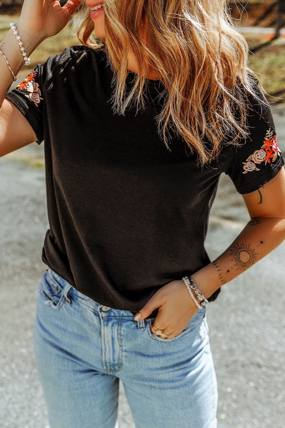 Camiseta negra con mangas cortas y cuello redondo bordado con flores