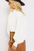 White textured top with puff sleeves and smocked mock neck