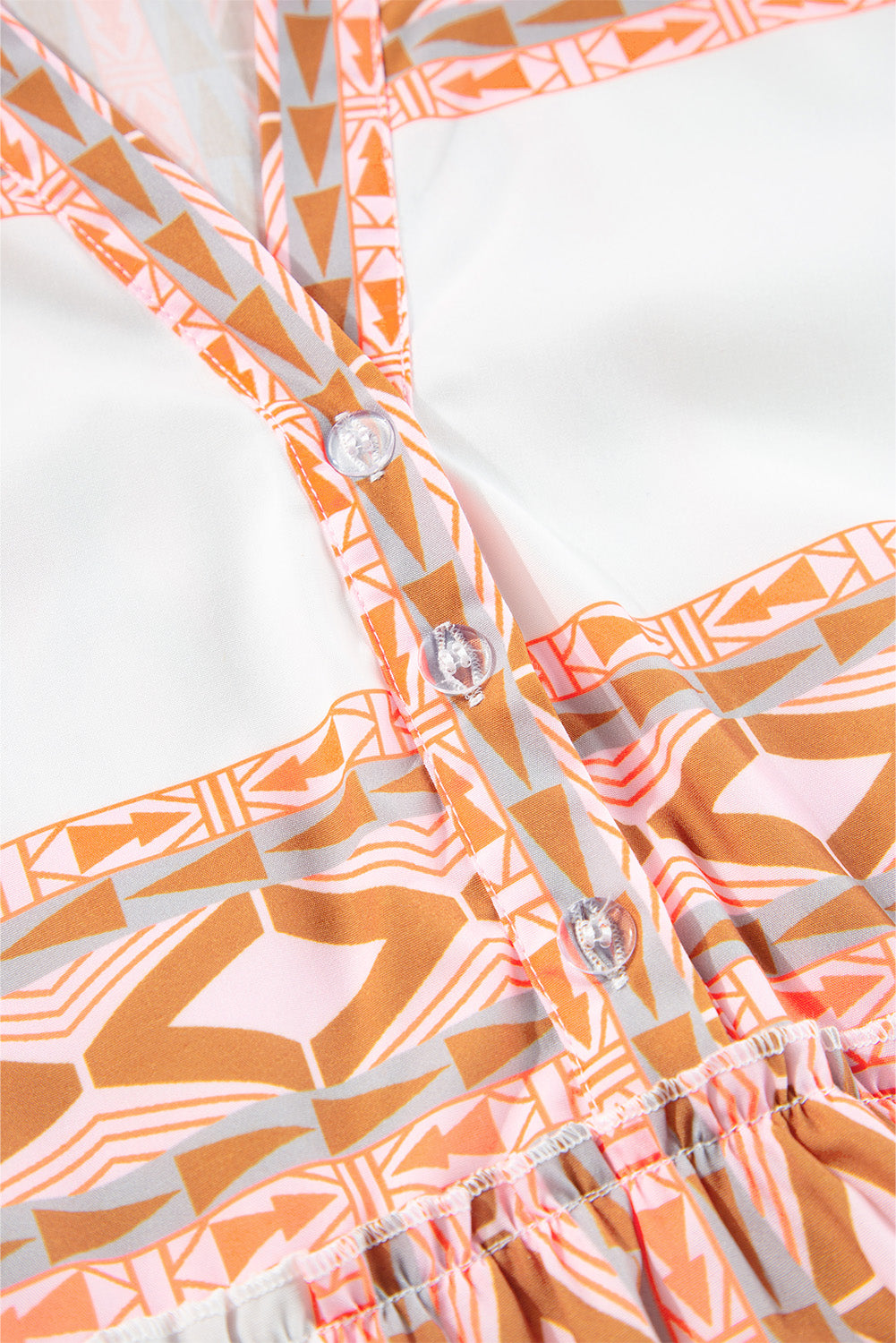 Robe orange à col en V et boutons à volants et imprimé géométrique