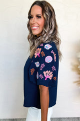 Chemisier bleu voile à col volanté et broderie de coquillages et de corail-A WOMAN WE LOVE