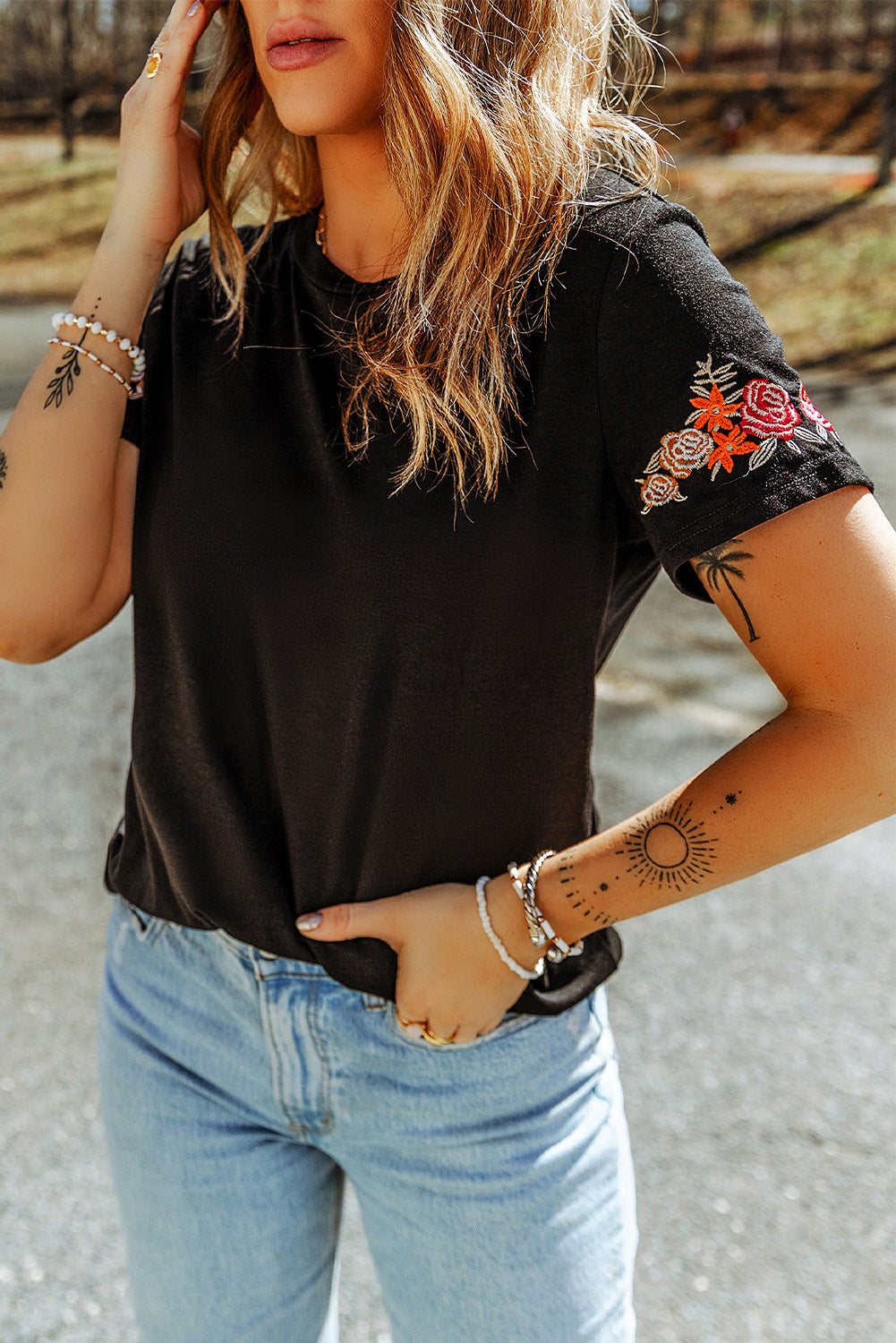 Camiseta negra con mangas cortas y cuello redondo bordado con flores