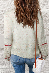 White sweater with patterned sleeves and pilled details