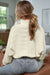 Beige sweater with dolman sleeves and buttoned stand-up collar with pearls