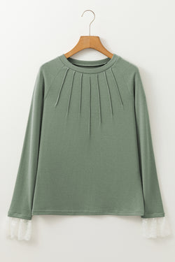 Grass green top with raglan sleeves and contrasting lace cuffs with contrasting stitching