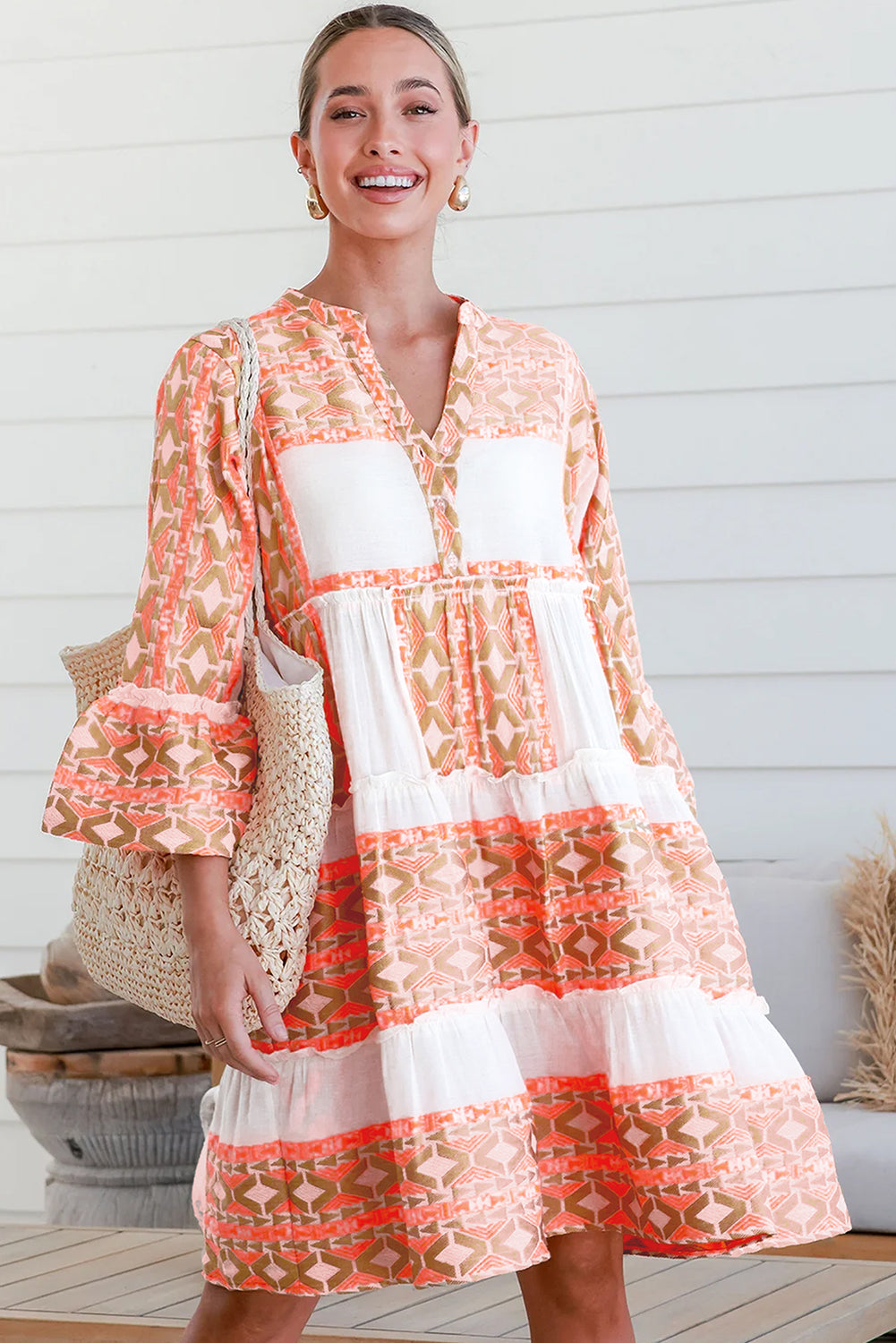 Robe orange à col en V et boutons à volants et imprimé géométrique