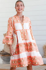 Robe orange à col en V et boutons à volants et imprimé géométrique